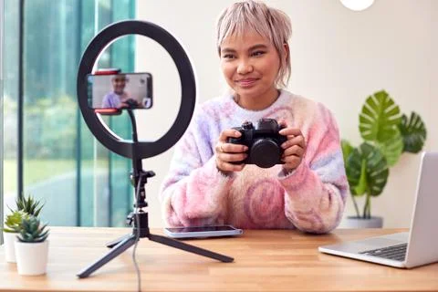 Female Vlogger Recording Camera Tutorial Video At Home With Mobile Phone Foto stock