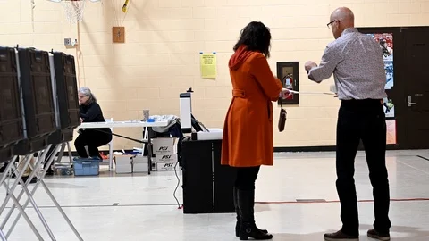Female voters inserts her marked ballot in scanner. Vidéo 126129151