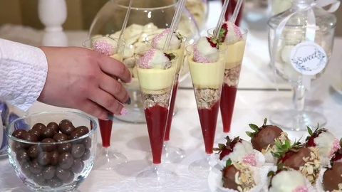Female waitress serving festive table, exposes chic sweets in a glasses Stock-Footage 110791212