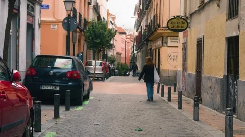 Female walking down cobble stone street in Spain Stock Footage 255863336