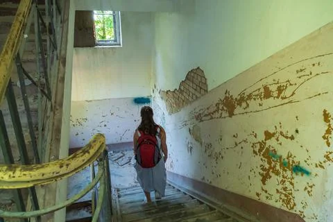 Female walking on steps inside desolate building Fotos de archivo