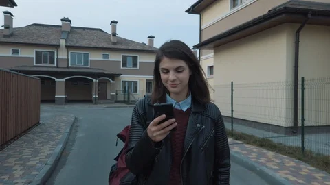 Female walking in a townhouse. Using smartphone on the go. looking around and s Video stock 128902889
