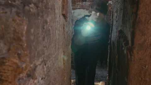 Female Wanderer Shining Flashlight into Narrow Wall in Scary Abandoned Place Stock Footage 250958357