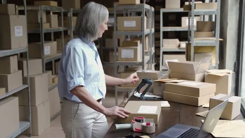 Female warehouse worker packing ecommerce parcel shipping box. 動画素材 141403335