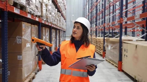 Female warehouse worker scanning and checking inventory Stock Footage 312856421