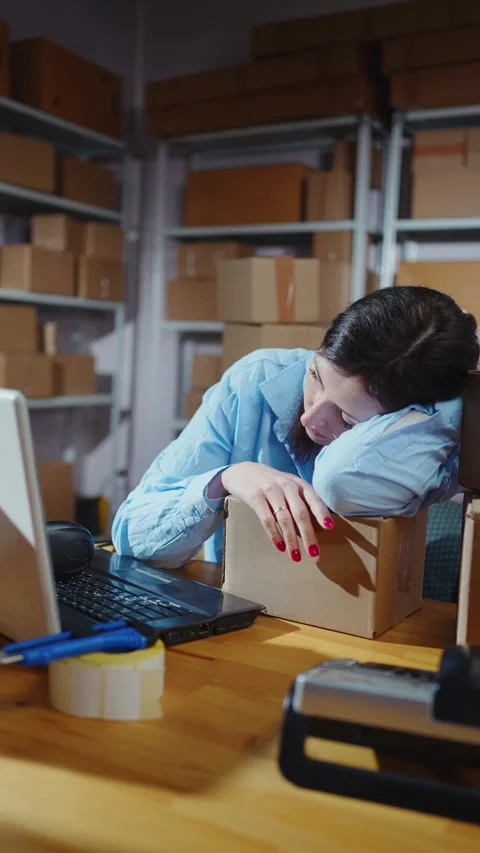 Female a warehouse worker sleeps at a table vertical video Stock Footage 276852317