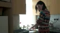 Female washing up, stops to answer phone HD Footage
