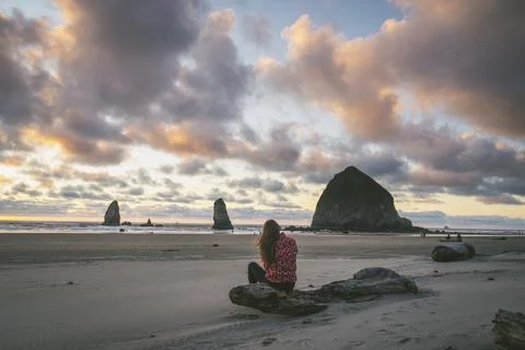Female watching sunset at Haystack Rock The Oregon Coast Stock Photos