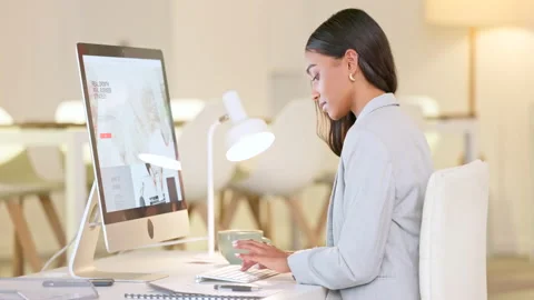 Female web designer typing on a computer and comparing graphic notes to a screen Stock Footage 202151993