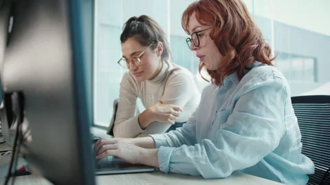Female web developers working on a computer program in an office Video stock 243376736