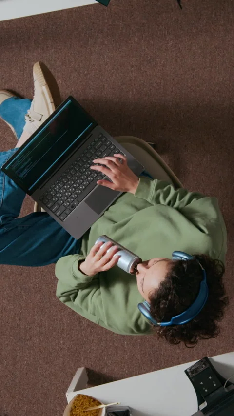 Female Web Engineer with Headphones Programming on Laptop Holding Can of Drink Stock Footage 312451108