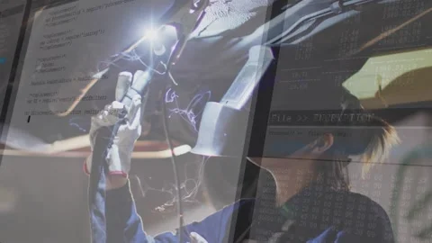 Female welder activating torch under car, sparking seam while clear auto code Stock Footage 319572658