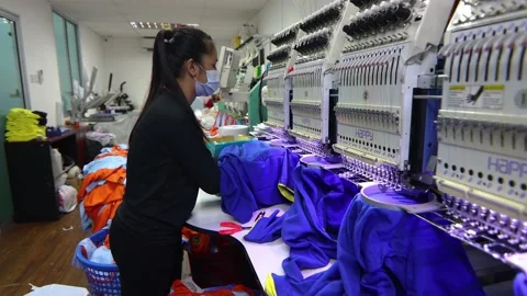 Female work with face mask cutting thread on staff uniform on Garment Manufac Stock Footage 161236744