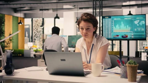 Female worker analyzing income data and performance metrics in corporate office Stock Footage 329325940