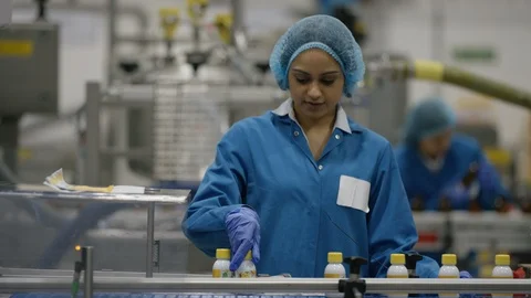 Female worker checking bottles and smiling at camera in cosmetic factory Video stock 107995893
