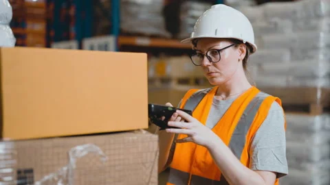 Female worker checking package using barcode reader in warehouse Stock Footage 163346827
