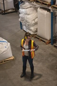 Female worker checking time while using digital tablet 写真素材