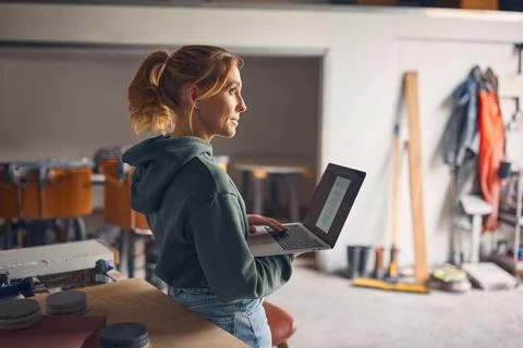 Female Worker In Concrete Workshop Using Laptop Computer Stock Photos