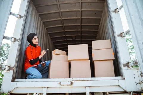 Female worker counting boxes of packages in a container Foto stock