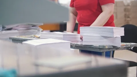 Female worker disassembles a stack of paper in the typography Stock Footage 88901407