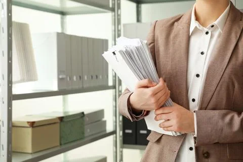 Female worker with documents in archive, closeup. Space for text Stock Photos