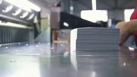 Female worker folds a stack of paper in the typography Stock Footage 88901345