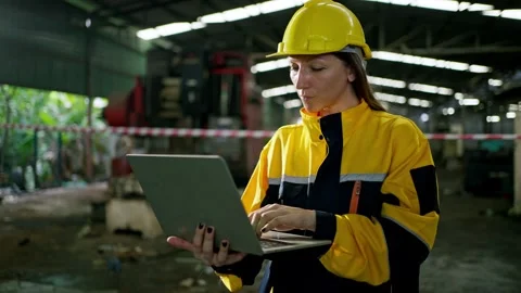 Female worker hard hat and safety jacket using laptop during factory and wa.. 動画素材 332503635