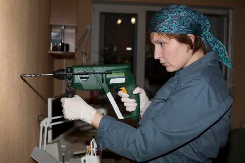 Female worker keeps electrical drill Stock Photos