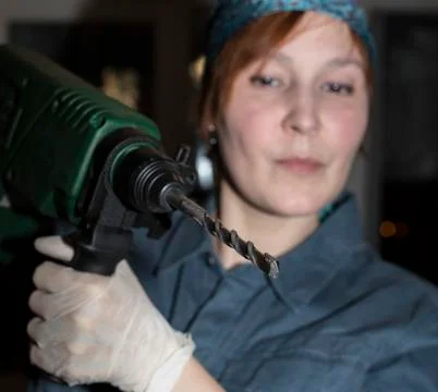 Female worker keeps electrical drill Foto stock