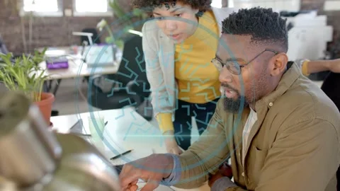 Female worker leaning in pointing at laptop, male worker typing HUD overlay Stock Footage 334014097
