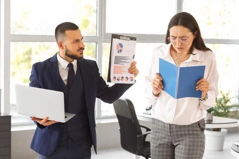 Female worker with notebook and her angry boss in office Stock Photos