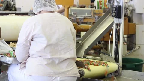 A female worker operator monitors the work of the conveyor Stock Footage 128643169
