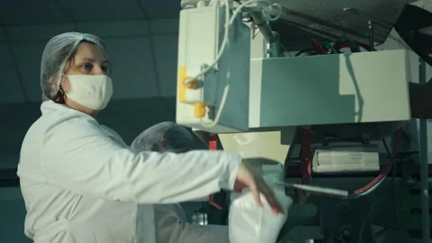 A female worker packs sugar using machine on conveyor belt of sugar beet plant. Stock Footage 145999574