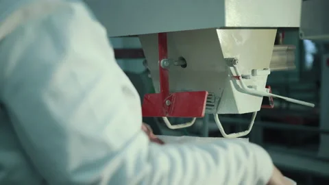A female worker packs sugar using machine on conveyor belt of sugar beet plant. Stock Footage 146000293