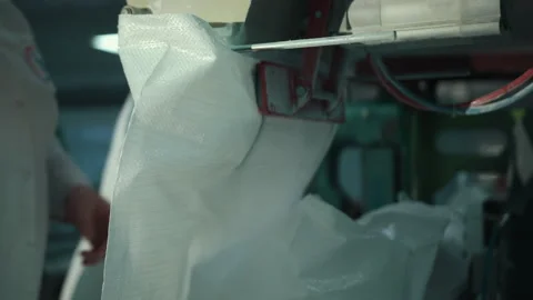 A female worker packs sugar using machine on conveyor belt of sugar beet plant. Stock Footage 146138573