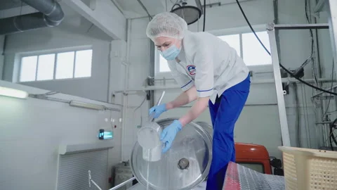 A Female worker is pouring milk samples into the small cup for quality testing Stock Footage 161731695