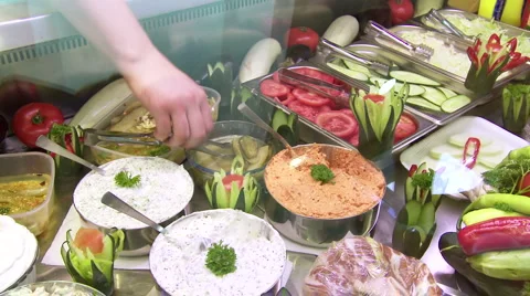 Female worker puts salad in sandwich at the fast food kiosk Stock Footage