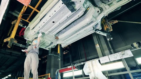 Female worker is putting zinc paste onto the car body Vídeo Stock 146511998