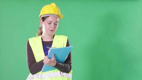 Female worker in reflective vest and hard helmet takes inventory and makes notes 動画素材 344848971