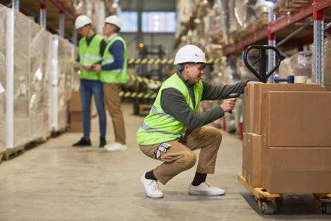 Female worker scanning codes on boxes in warehouse Stock Photos
