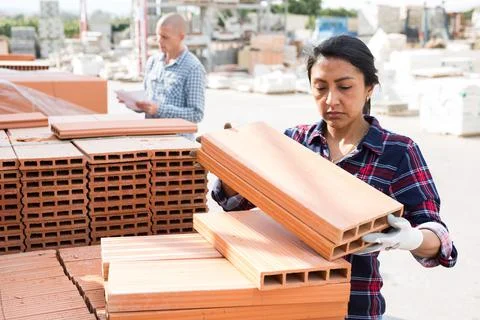 Female worker stacking bricks in warehouse of materials Stock Photos
