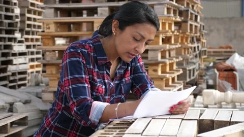 Female worker with tablet checking quantity of paving slabs in warehouse of Stock Footage 221212909