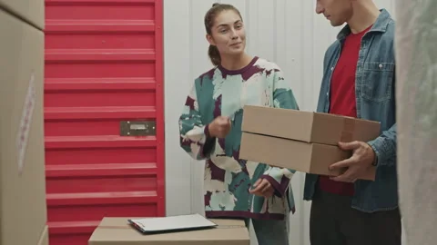 Female Worker Taking Notes and Instructing Client in Self Service Storage Stock Footage 259828294