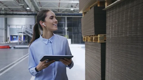 Female worker talking on and checking product quantity in factory Stock Footage 108483248
