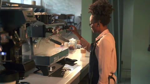 Female worker turning on coffee machine and standing in cafe kitchen during Stock Footage 158916426