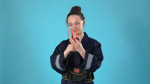 Female Worker in Uniform Using Scissors to Unpack Tape Measure Video stock 346111469