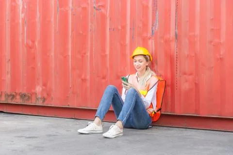 Female worker using mobile smartphone in industry containers cargo Fotos Stock
