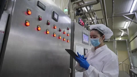 A female worker using tablet to inspect the accuracy of machinery in a processed Stock Footage 329904654