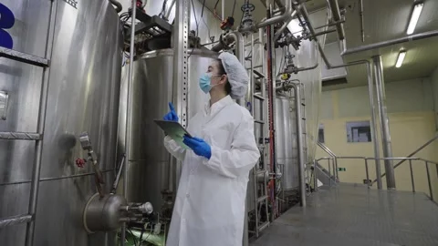 A female worker using tablet to inspect the accuracy of machinery in a processed Stock Footage 329904668