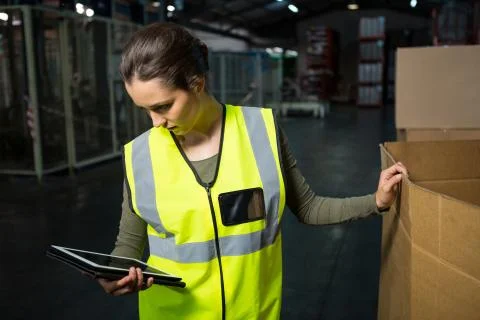 Female worker using tablet pc in warehouse 스톡 사진